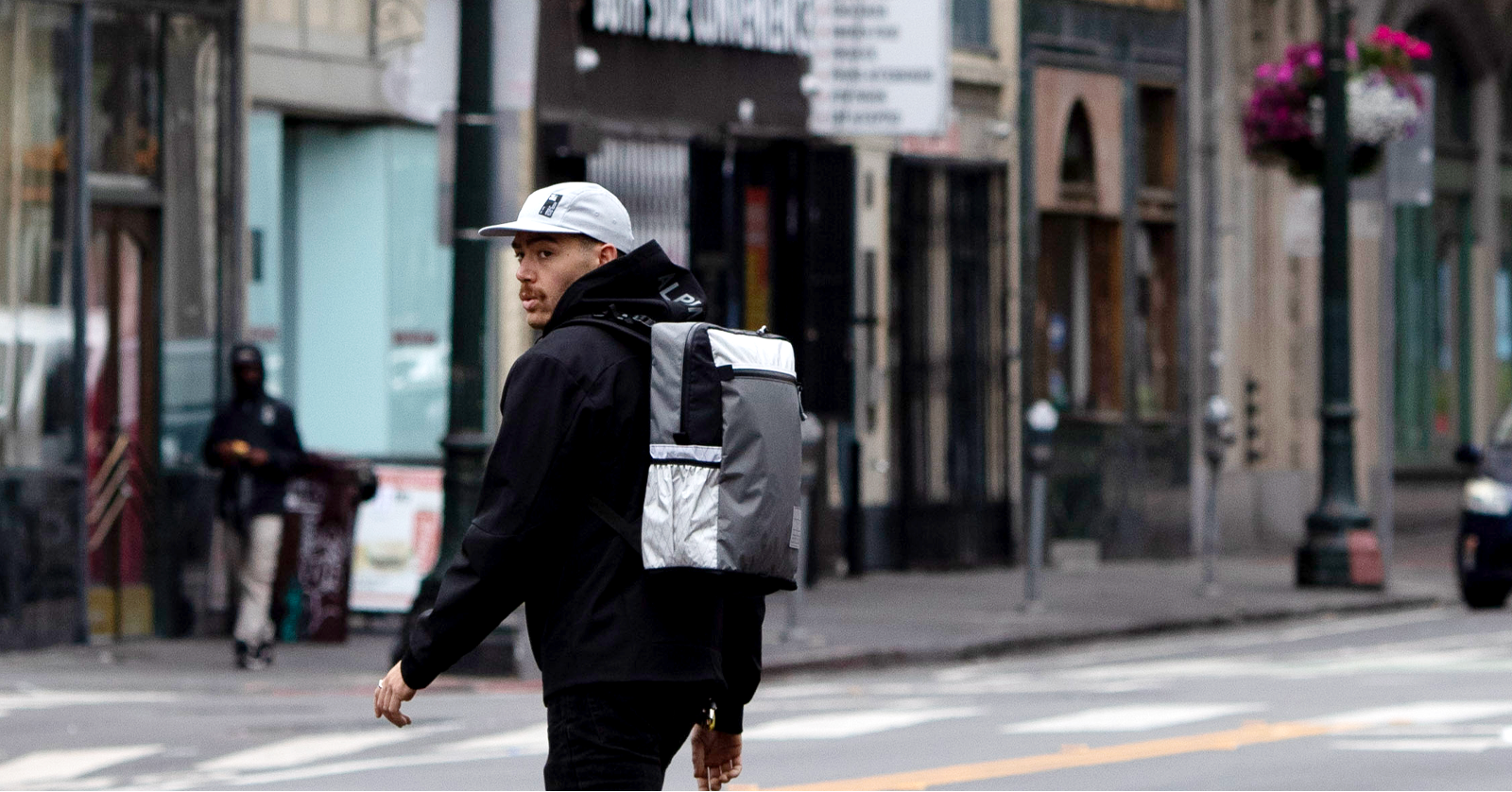 Person walking on a city street with a backpack